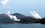 イメージ（噴煙を上げる新火口と温泉街）